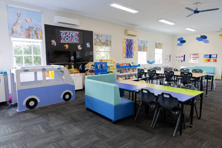 Library space with desks, chairs and books.