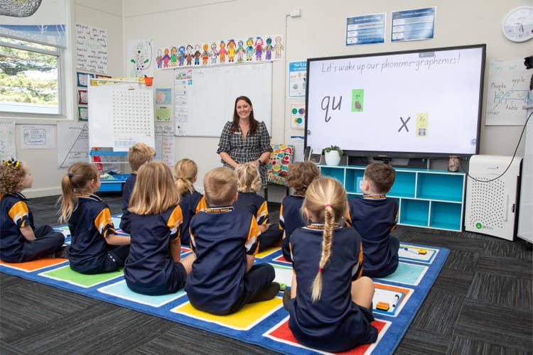 Students on carpet and teacher teaching