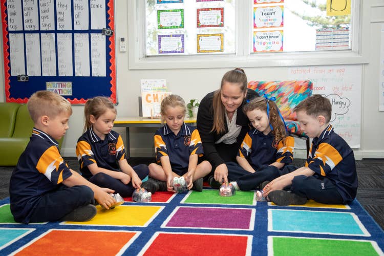 Group of students with teacher using robots