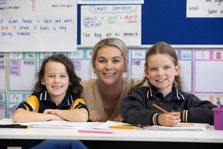 Students and teacher at desk